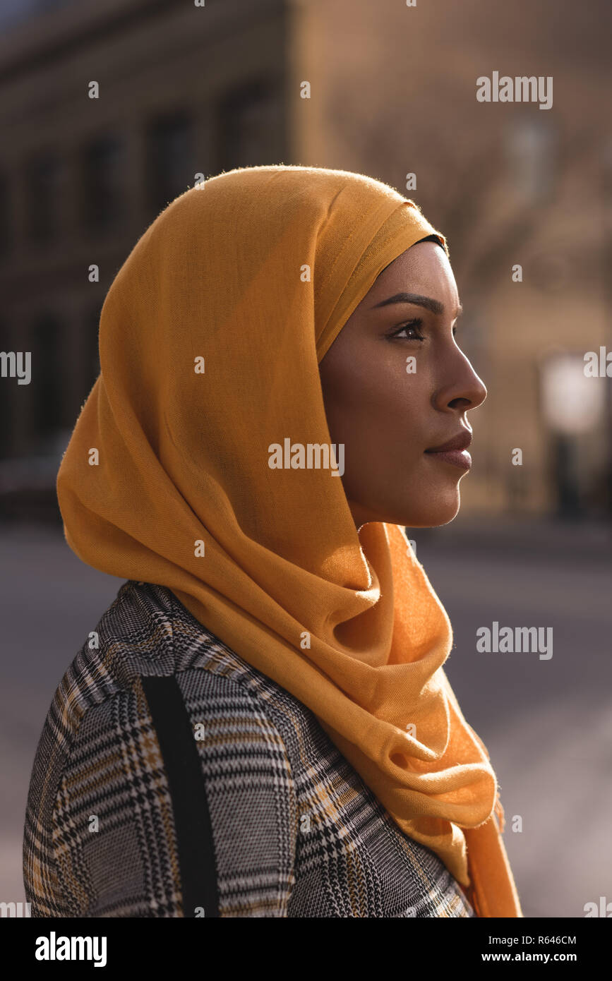 Thoughtful woman standing in city Stock Photo