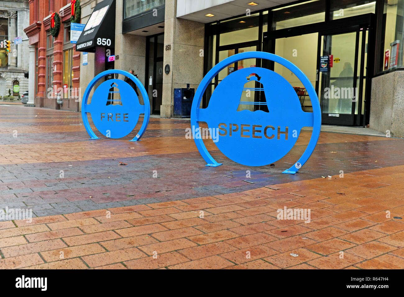 Two blue metal signs in the middle of the sidewalk in downtown Cleveland, Ohio outside The Cleveland City Club state 'Free' 'Speech'. Stock Photo