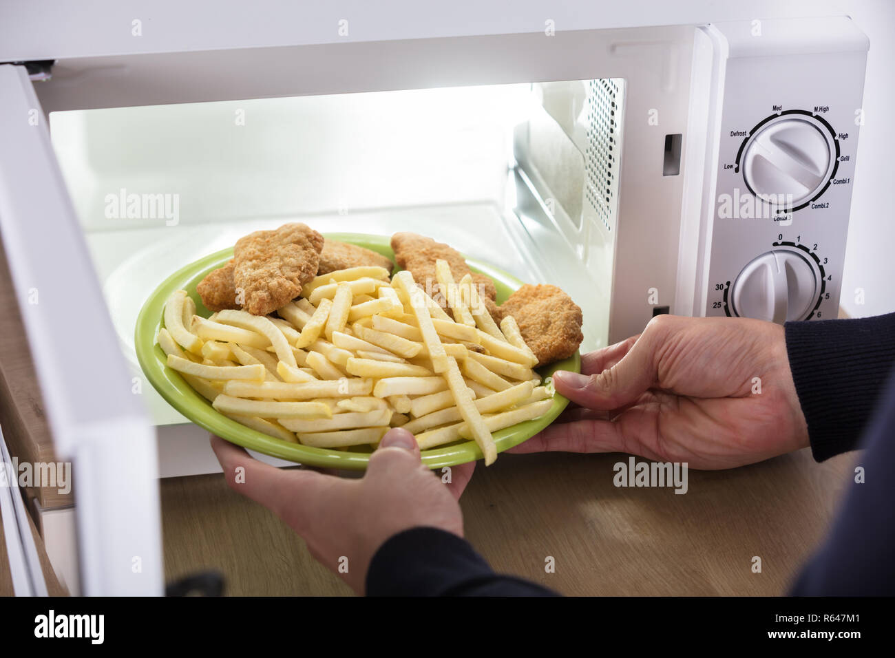 Person Putting Fried Food Inside Microwave Oven Stock Photo Alamy