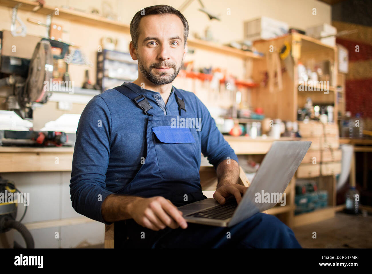 Mature Carpenter Posing with Laptop Stock Photo