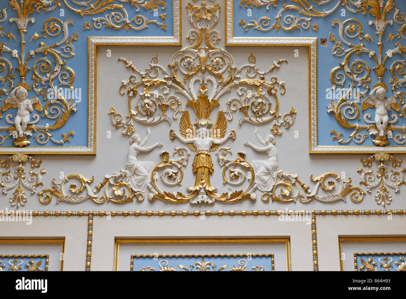 Wall with gilded carvings on white and blue panels showing floral design with cupids and angels. Hermitage State Museum, St Petersburg, Russia. Stock Photo