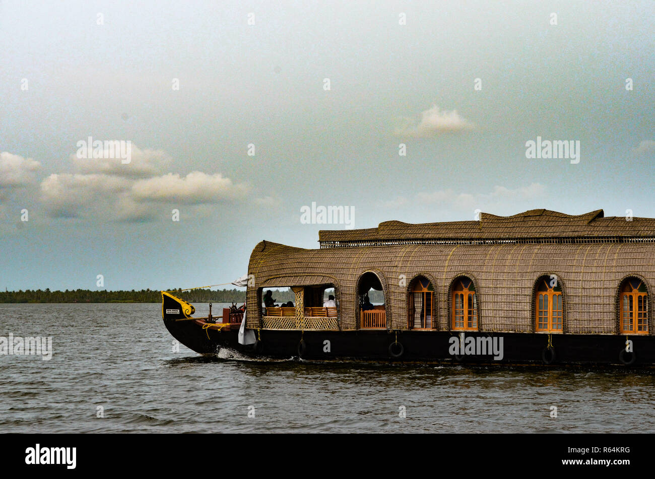 Beautiful view of houseboat in Alleppey (Alappuzha) backwaters in Kerala, India. Shot against background of blue sky and  backwaters. Stock Photo