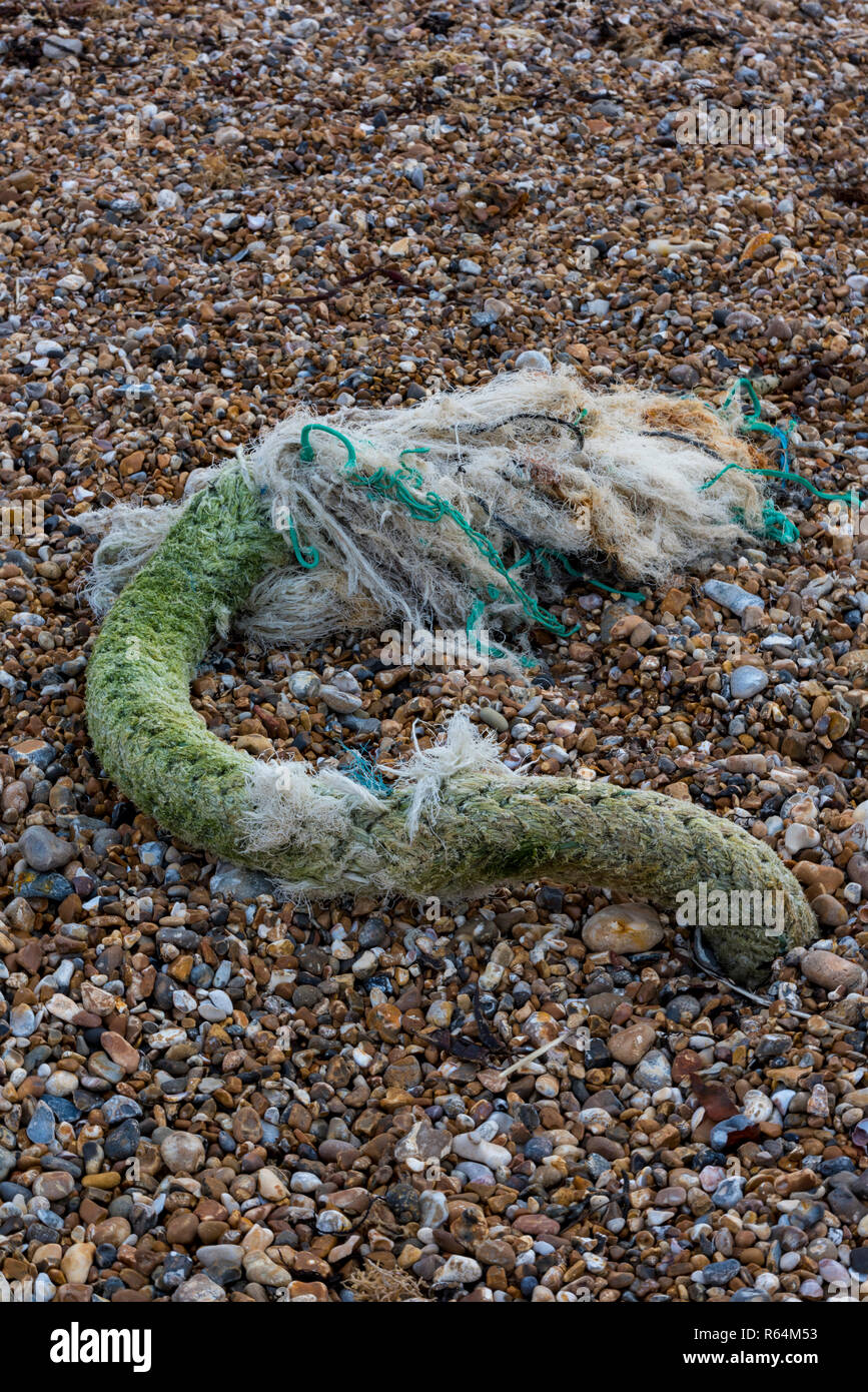 a large rope discarded on a beach. old fishing gear on the beach. Stock Photo