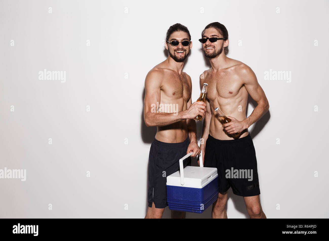 Portrait of a two laughing muscular shirtless twin brothers isolated ...