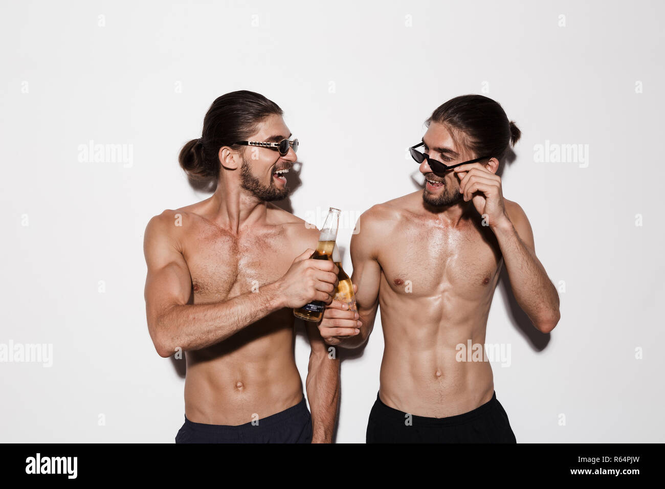 Portrait of a two laughing muscular shirtless twin brothers isolated ...