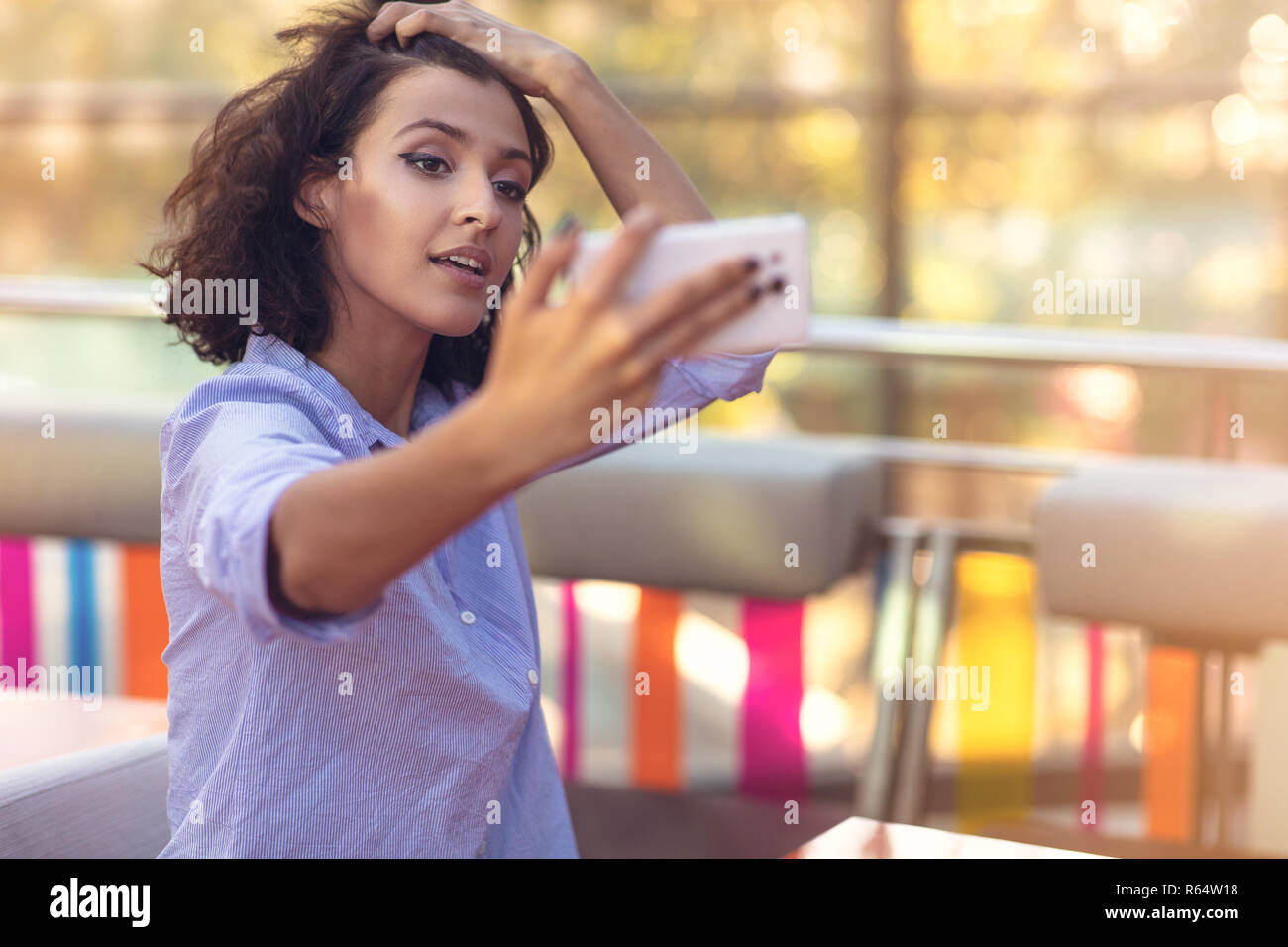 Young woman taking a selfie in coffee shop Stock Photo - Alamy