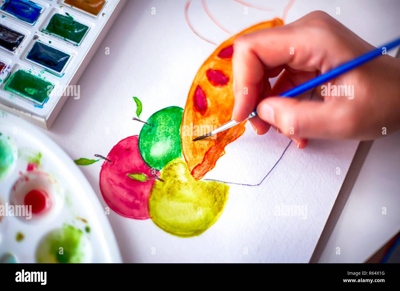 Woman hand with paint brush drawing apples and pie. Close-up. Stock Photo