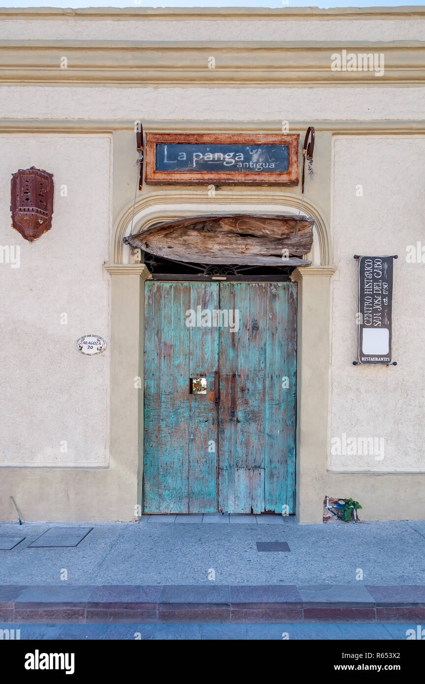 Turquoise blue doors of entrance to La Panga Antigua restaurant in Old Town San Jose del Cabo, Los Cabos, Mexico. A small wooden boat above doors. Stock Photo