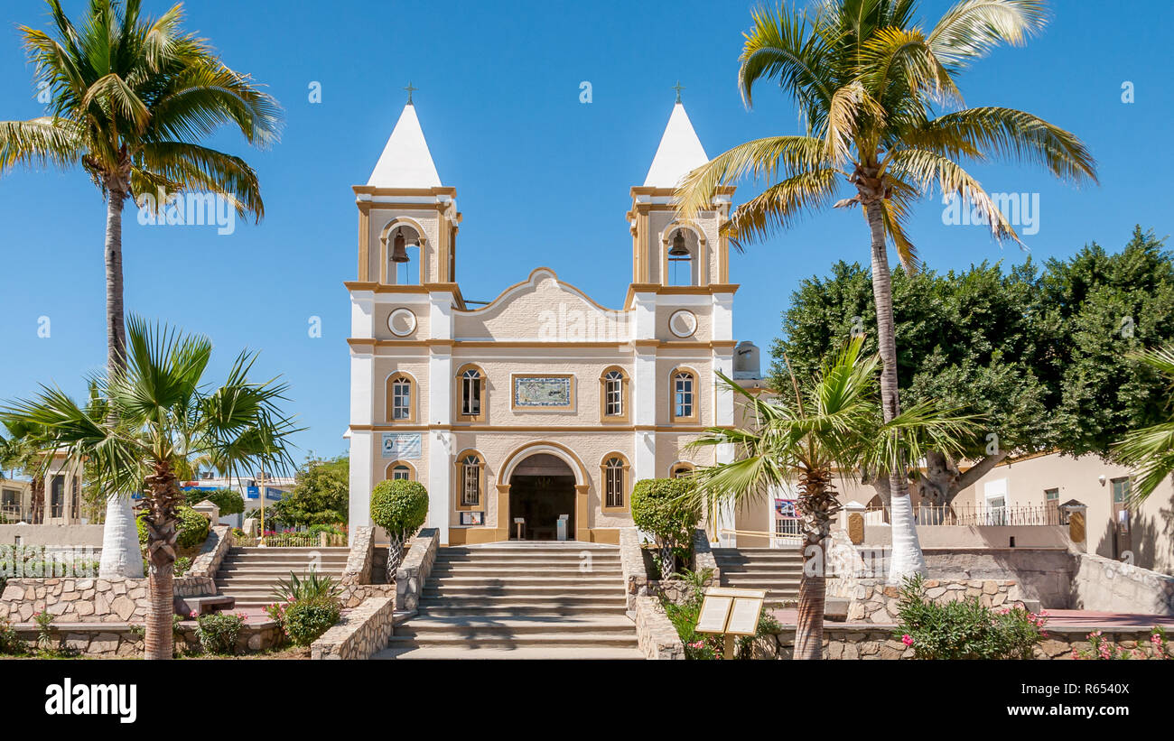 Front view of Parroquia San José the catholic church in old town San Jose del Cabo, Mexico, with two bell towers and palm trees on a sunny day. Stock Photo