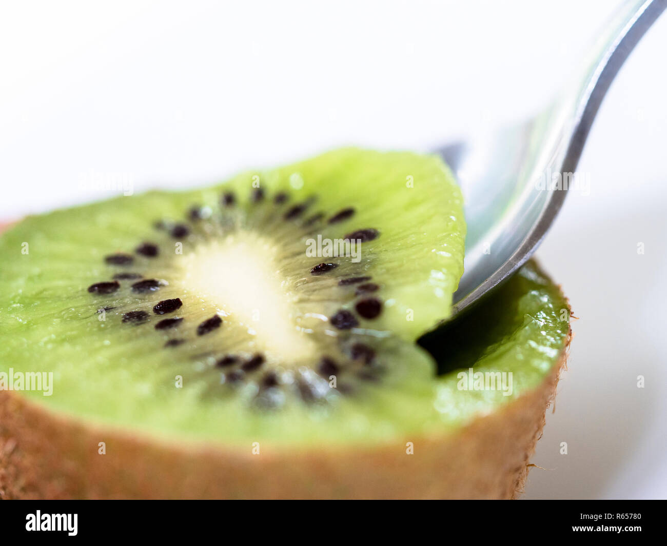 Spooning centre of kiwi fruit Stock Photo