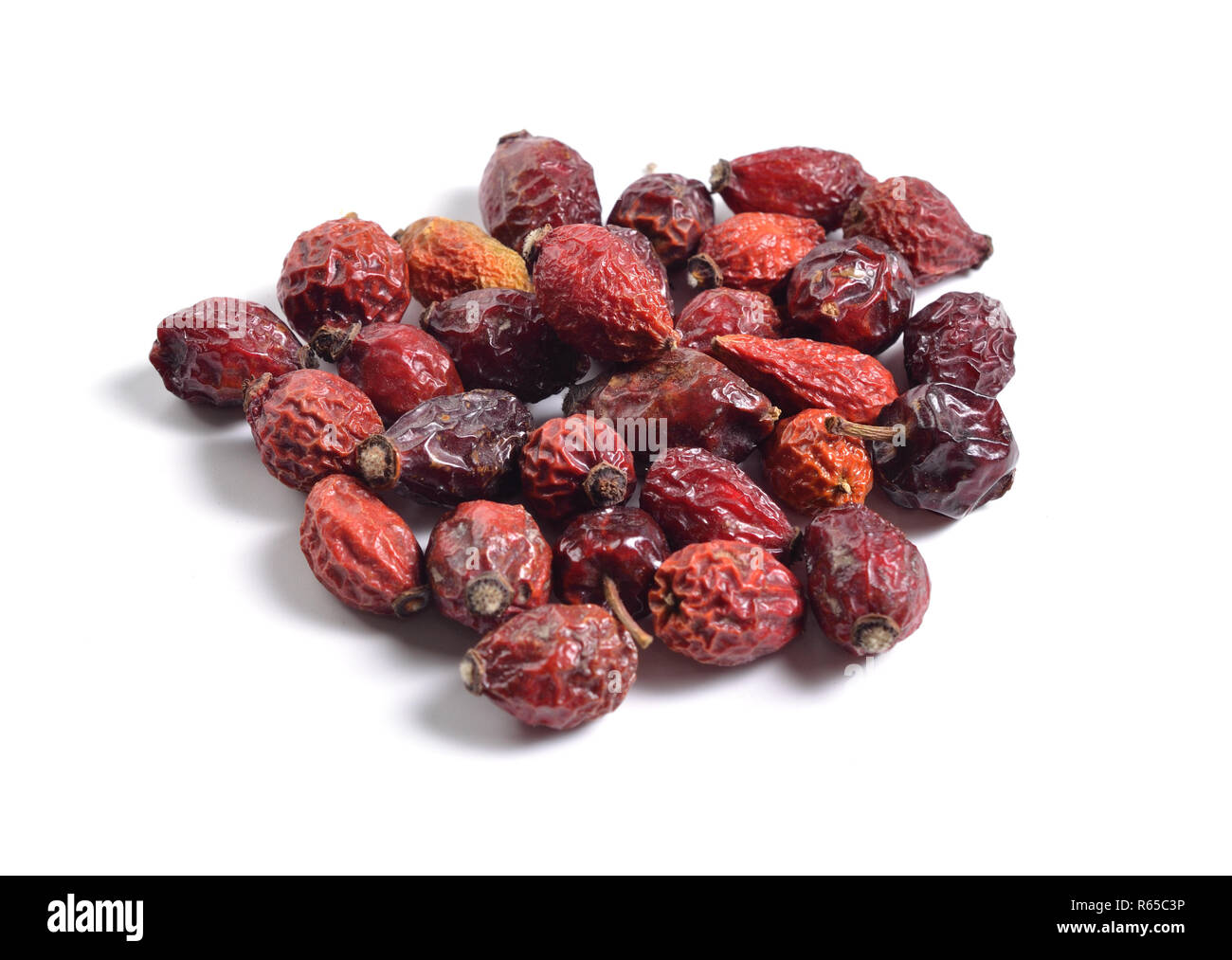 Dried medicinal herbs raw materials isolated on white. Dogrose or Rosa canina hips Stock Photo