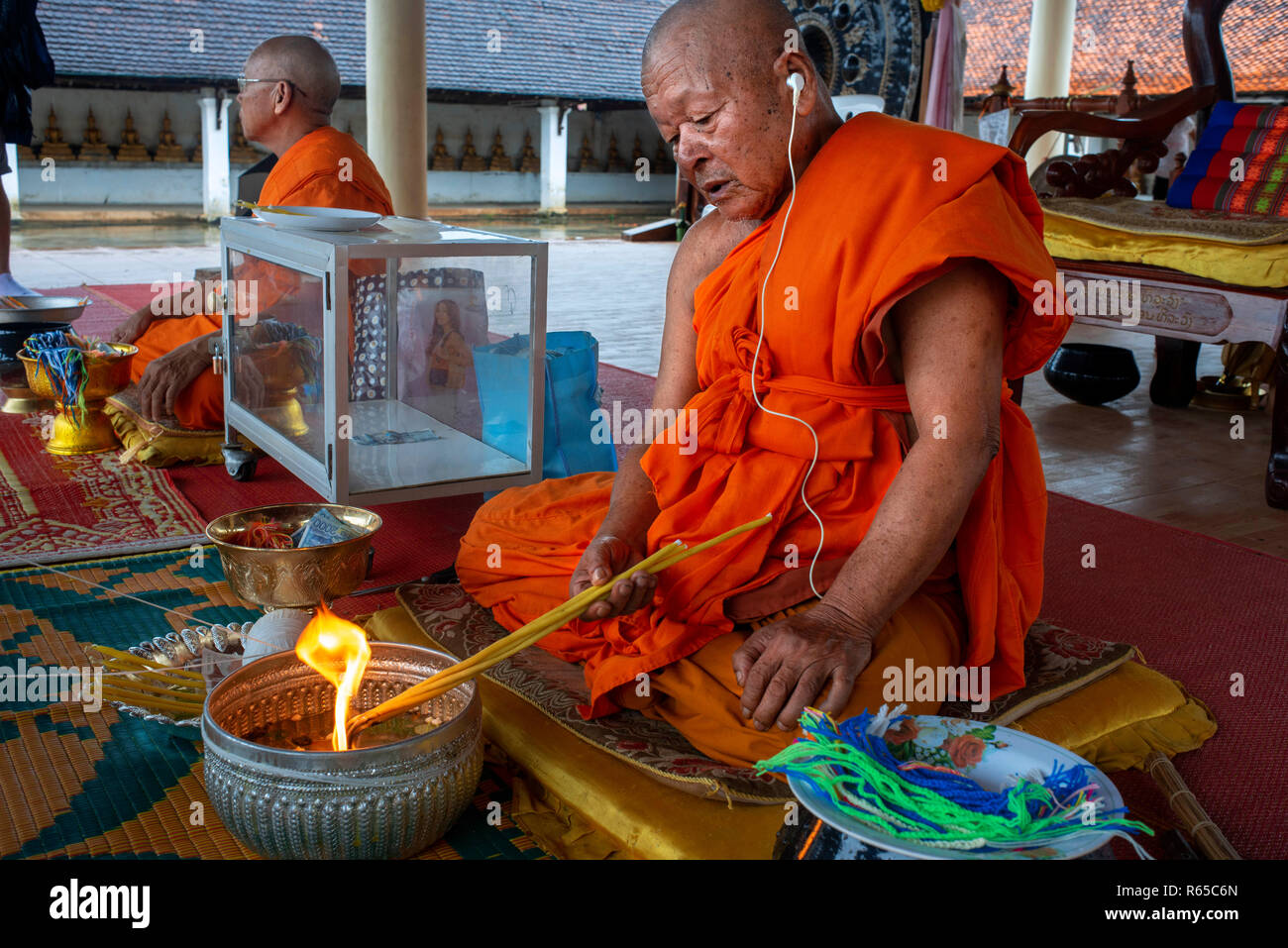 Buddhist monk blesses people in That Ing Hang Stupa, in Savannakhet, Laos, Southeast Asia Stock Photo