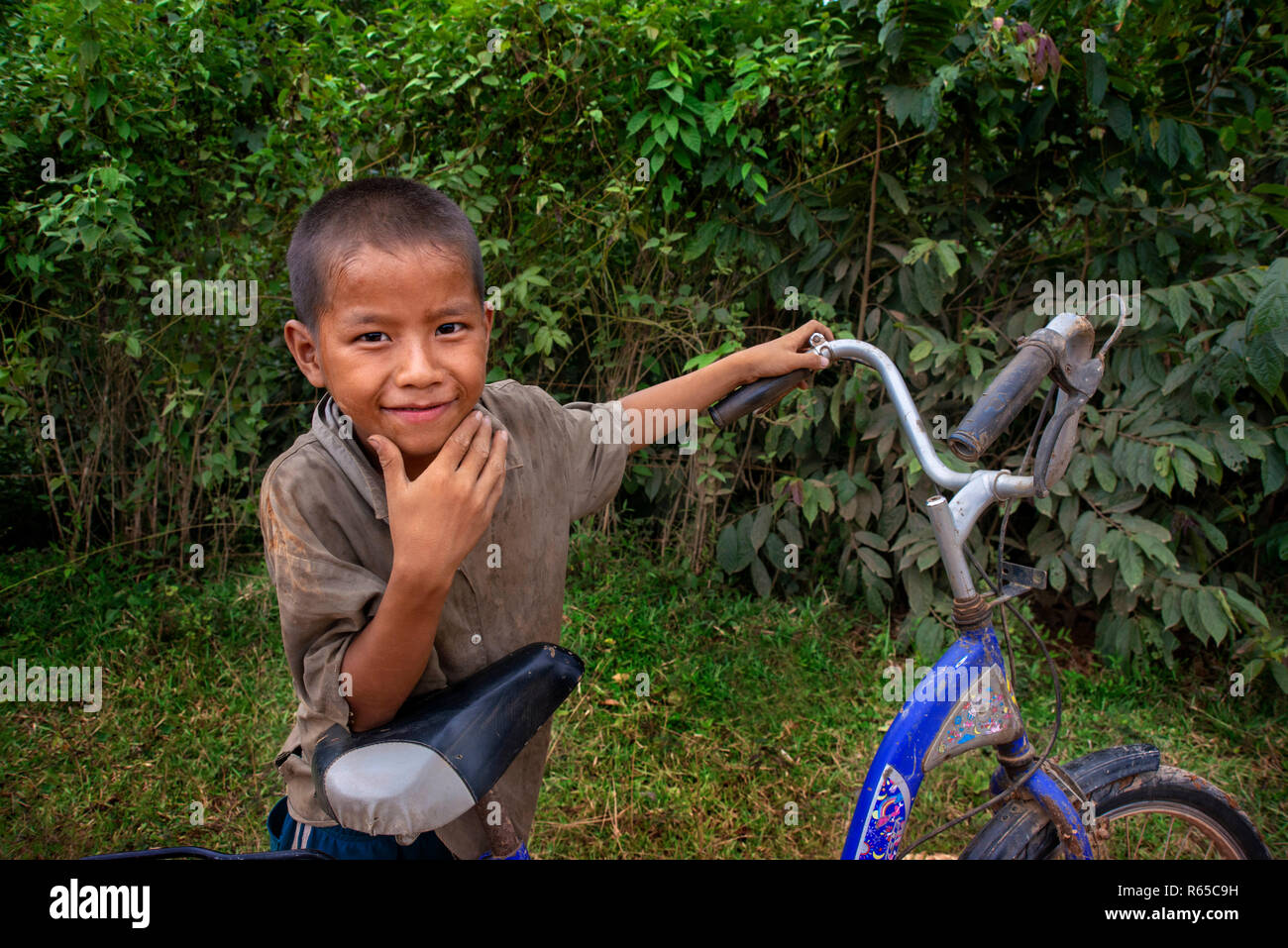 Young local boy with a bicycle in Vang Vieng village, Laos Stock Photo