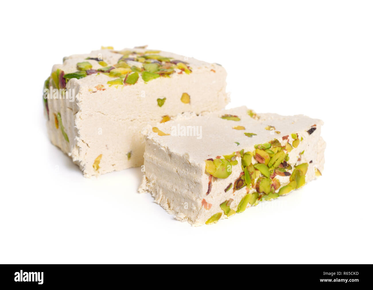 Tahini-based halva with pistachios. Isolated on white background. Stock Photo