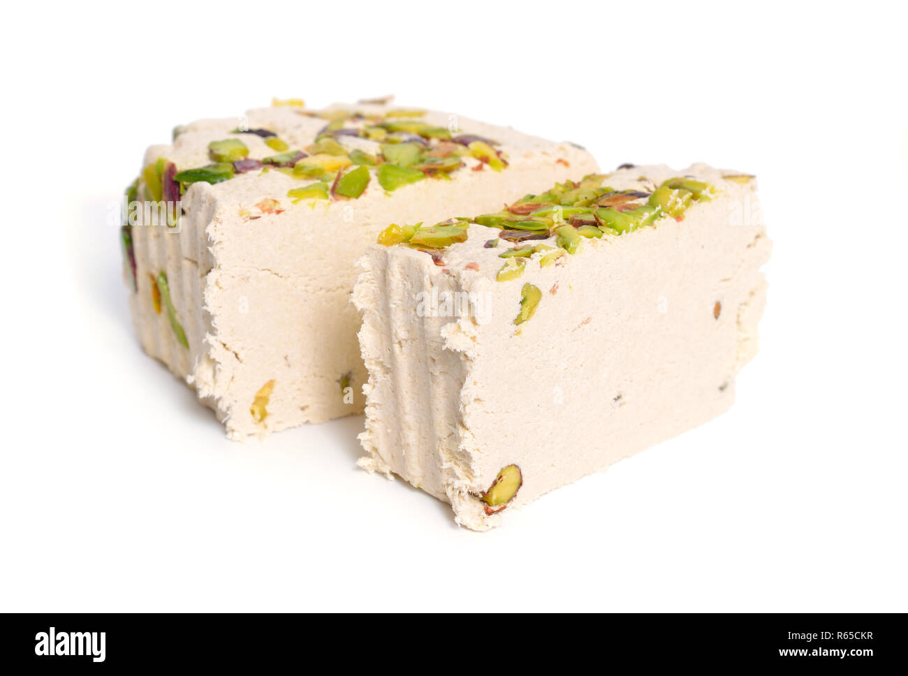 Tahini-based halva with pistachios. Isolated on white background. Stock Photo