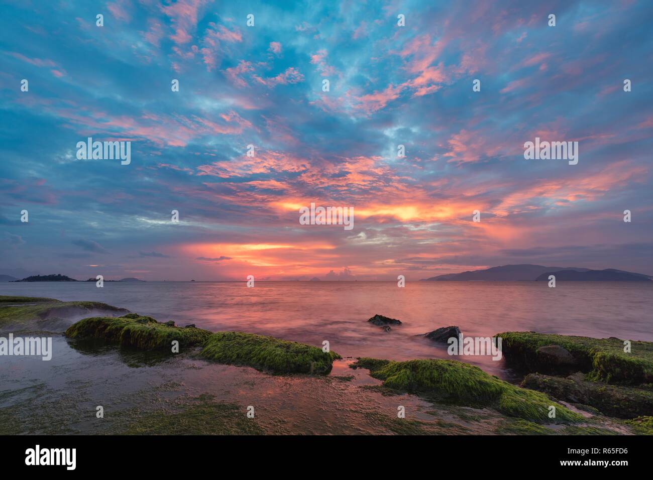 Vietnam In Nha Trang Bay Just Before Sunrise With Moss Covered Rocks In The Foreground Stock Photo Alamy