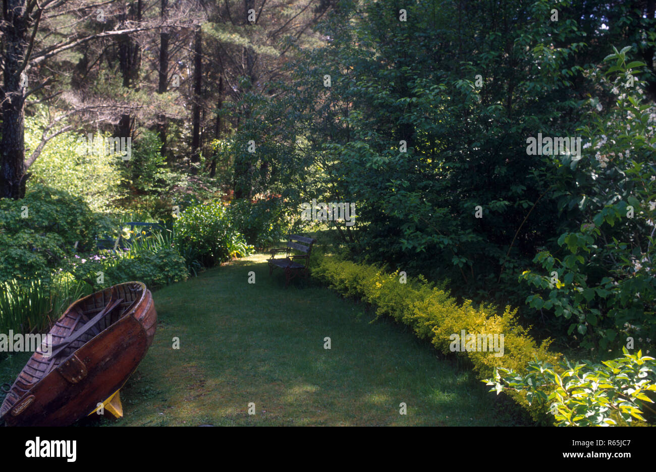 COUNTRY GARDEN SCENE AND OLD ROWING BOAT AS A FEATURE IN THE BLUE