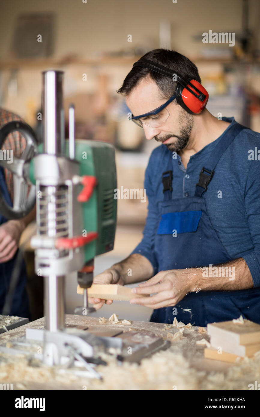 Mature Worker Drilling Wood Stock Photo