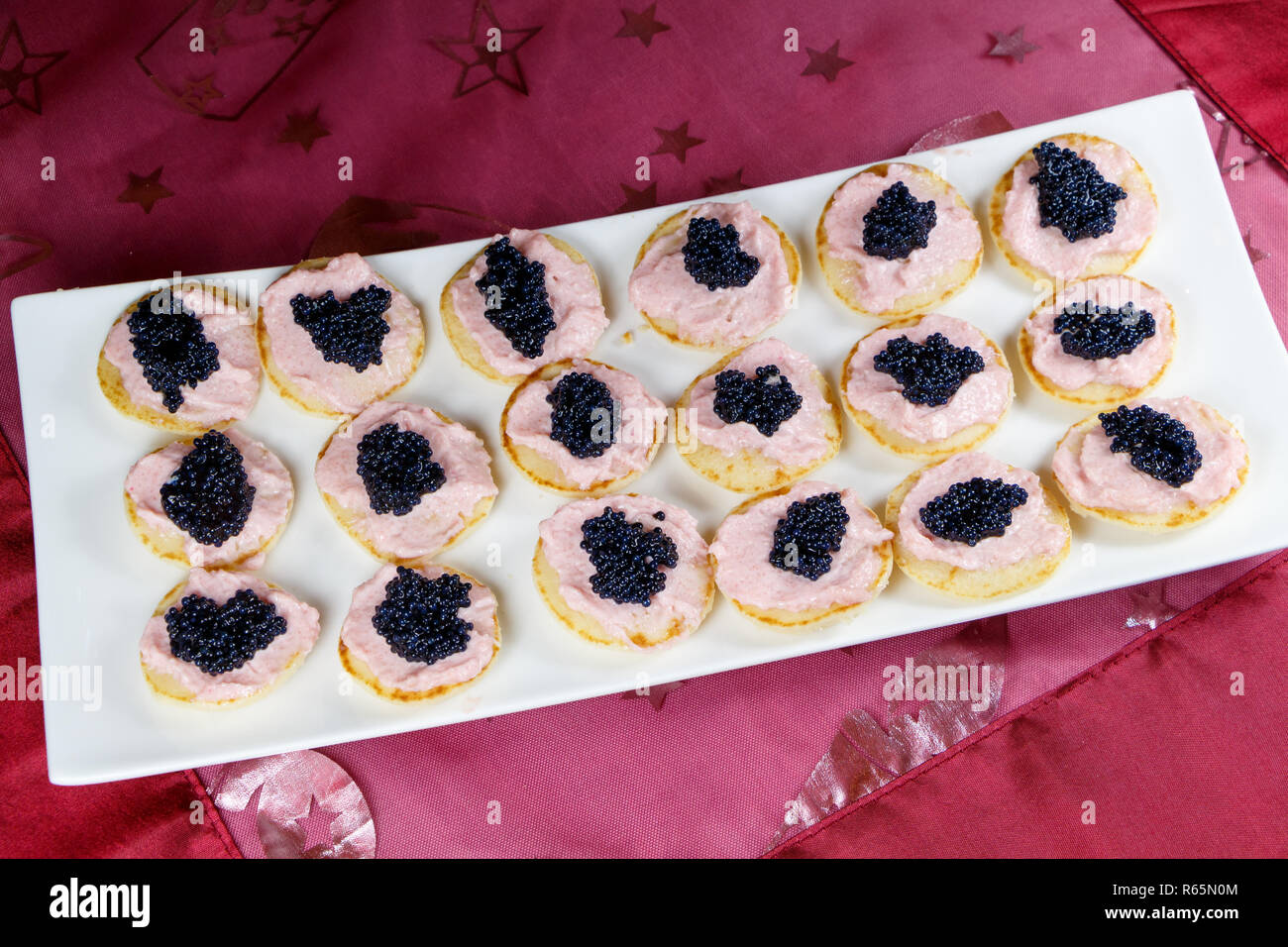 Blinis with taramasalata and lump-fish roe on a white dish for a party Stock Photo