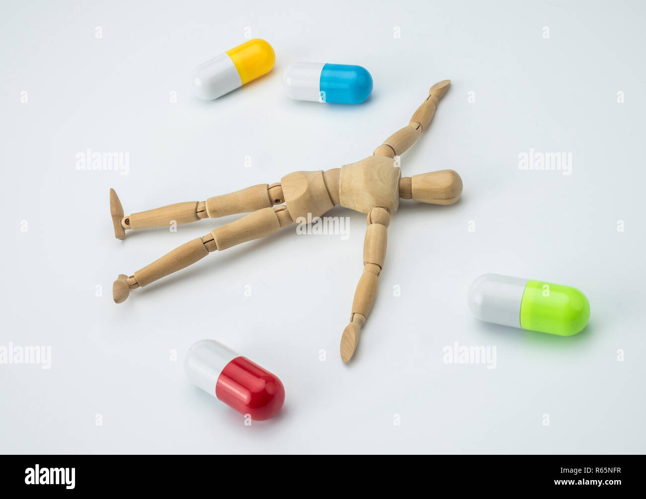 Doll articulated died of an overdose of pills, conceptual image Stock Photo