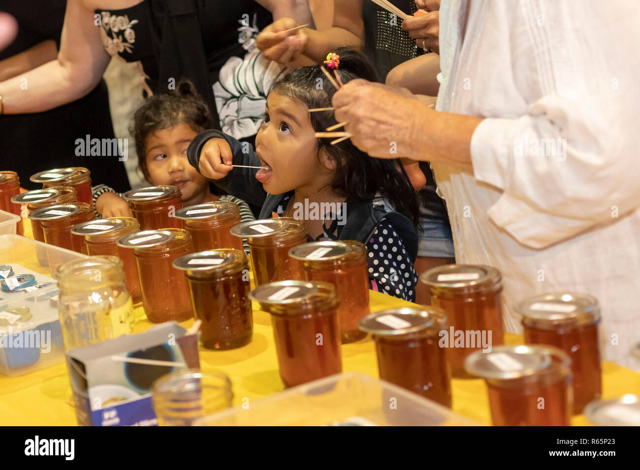 Hilo, Hawaii - A honey taste testing during the annual Black and White Night. People were encouraged to vote for their favorite honeys. Black and Whit Stock Photo
