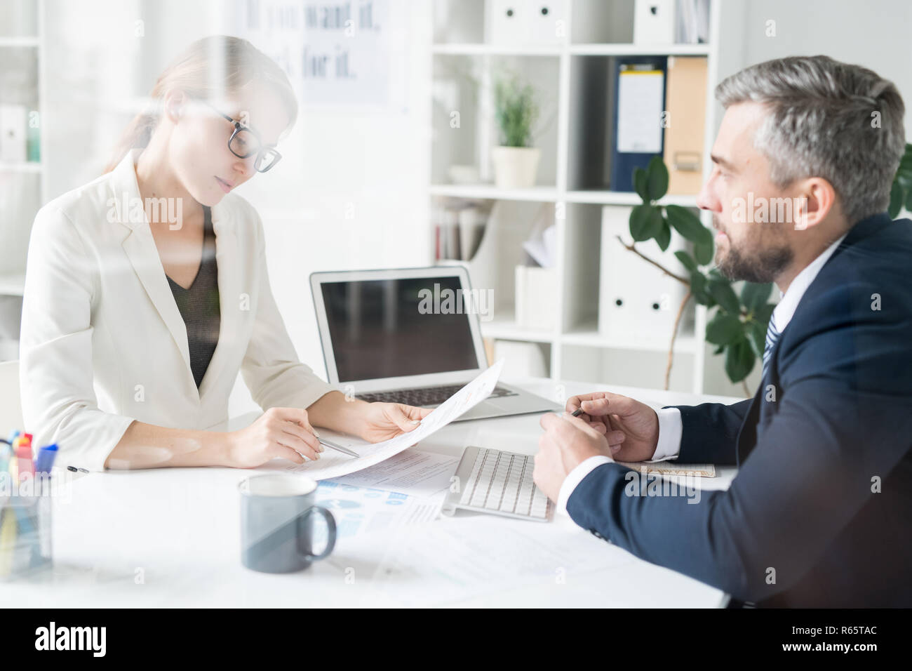 Financial adviser analyzing papers with businessman Stock Photo