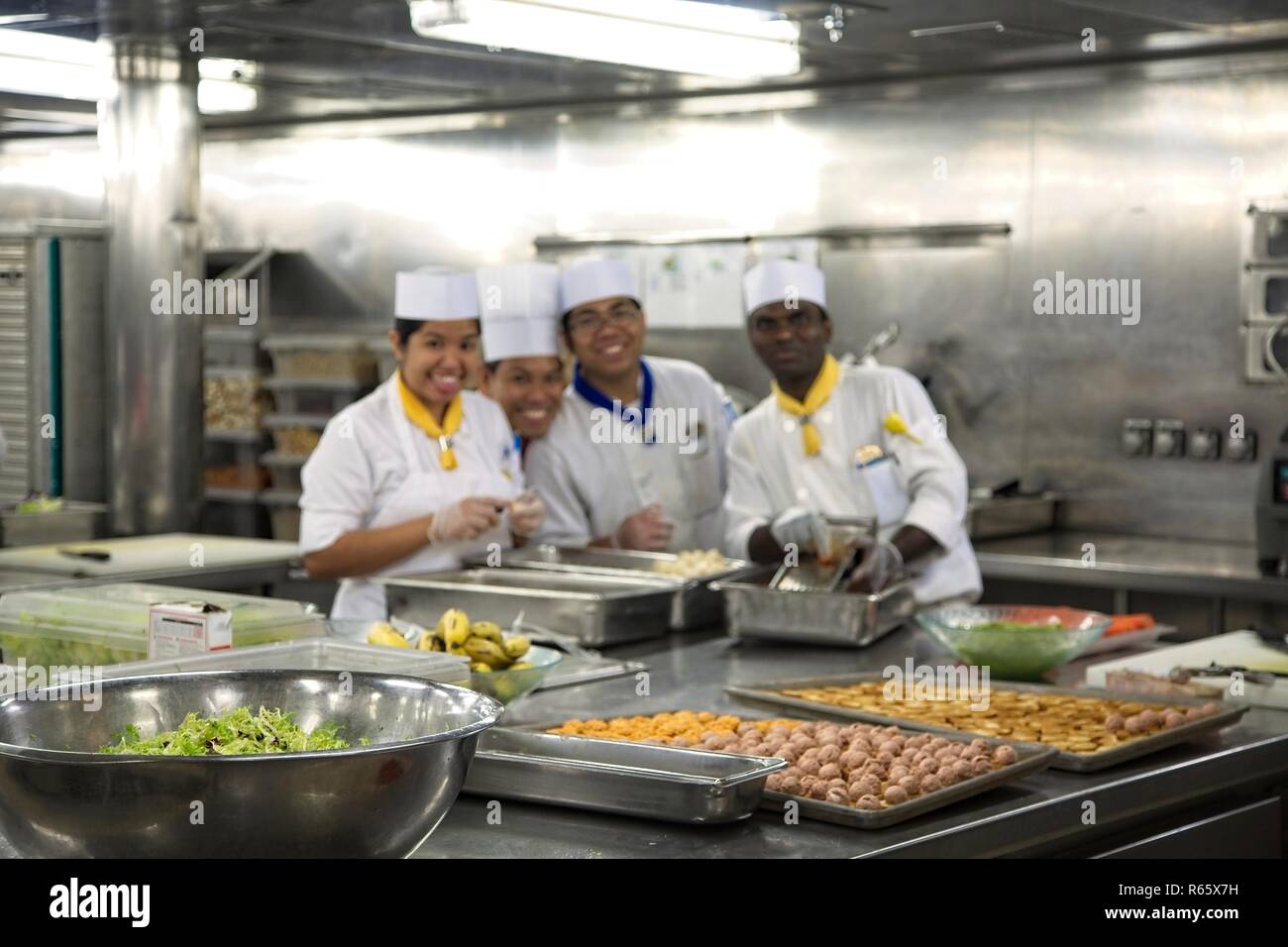 Food Prep Chefs working in a stainless steel commercial kitchen Stock