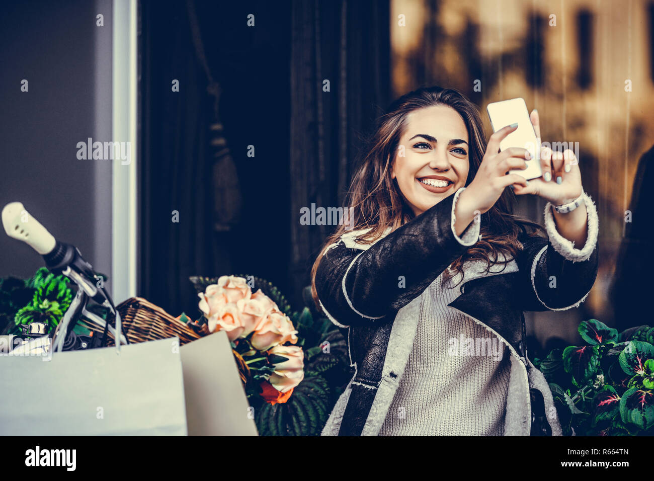 Smiling young woman making selfie photo on smartphone, afrer shopping Stock Photo