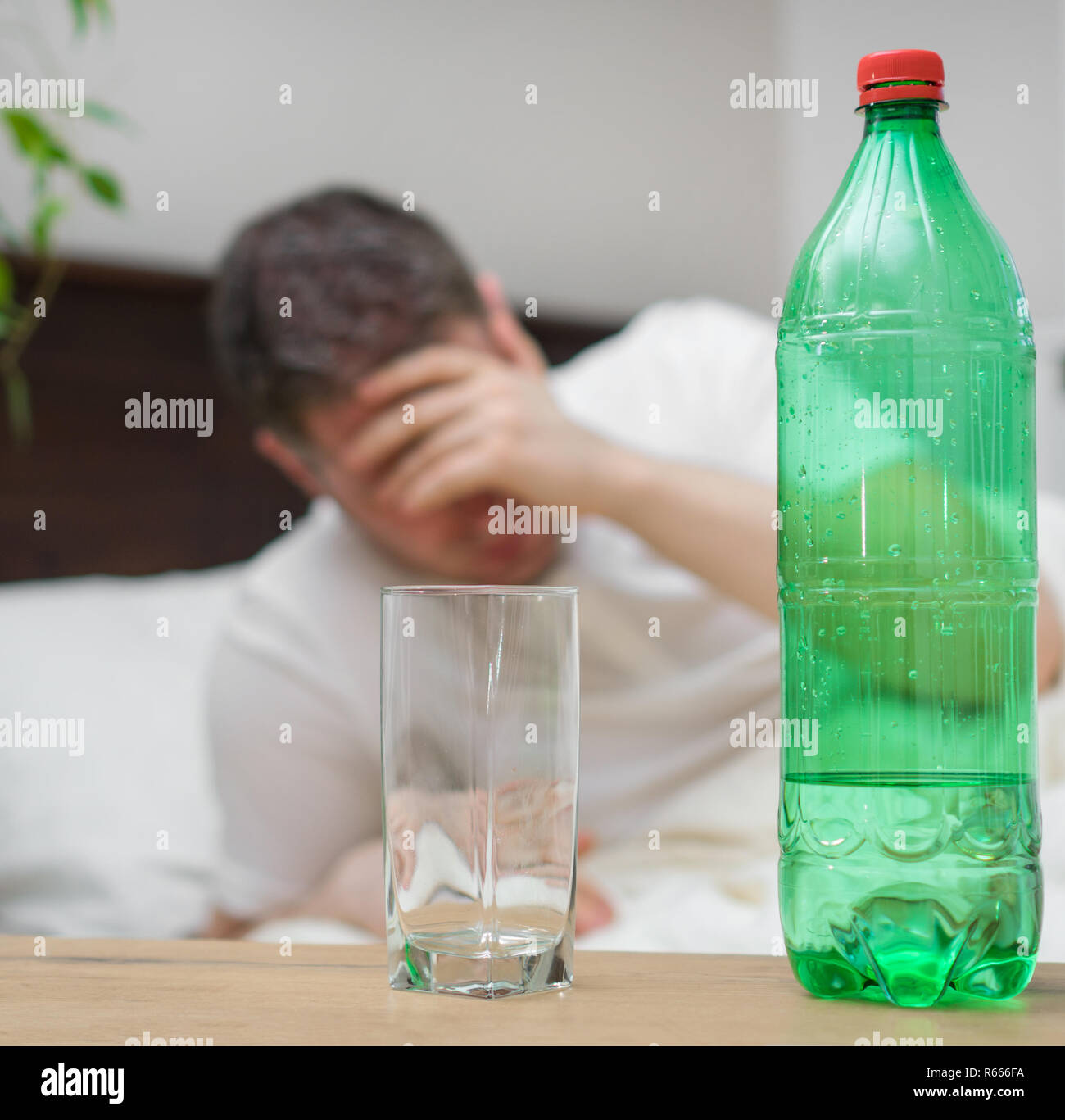 Man drinking mineral water and suffering from hangover Stock Photo Alamy
