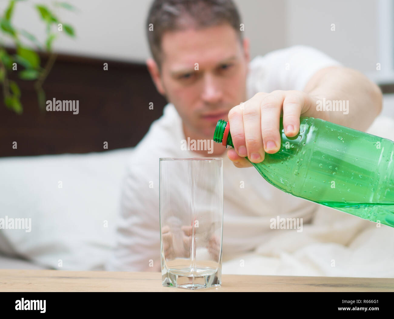 Man drinking mineral water and suffering from hangover Stock Photo Alamy