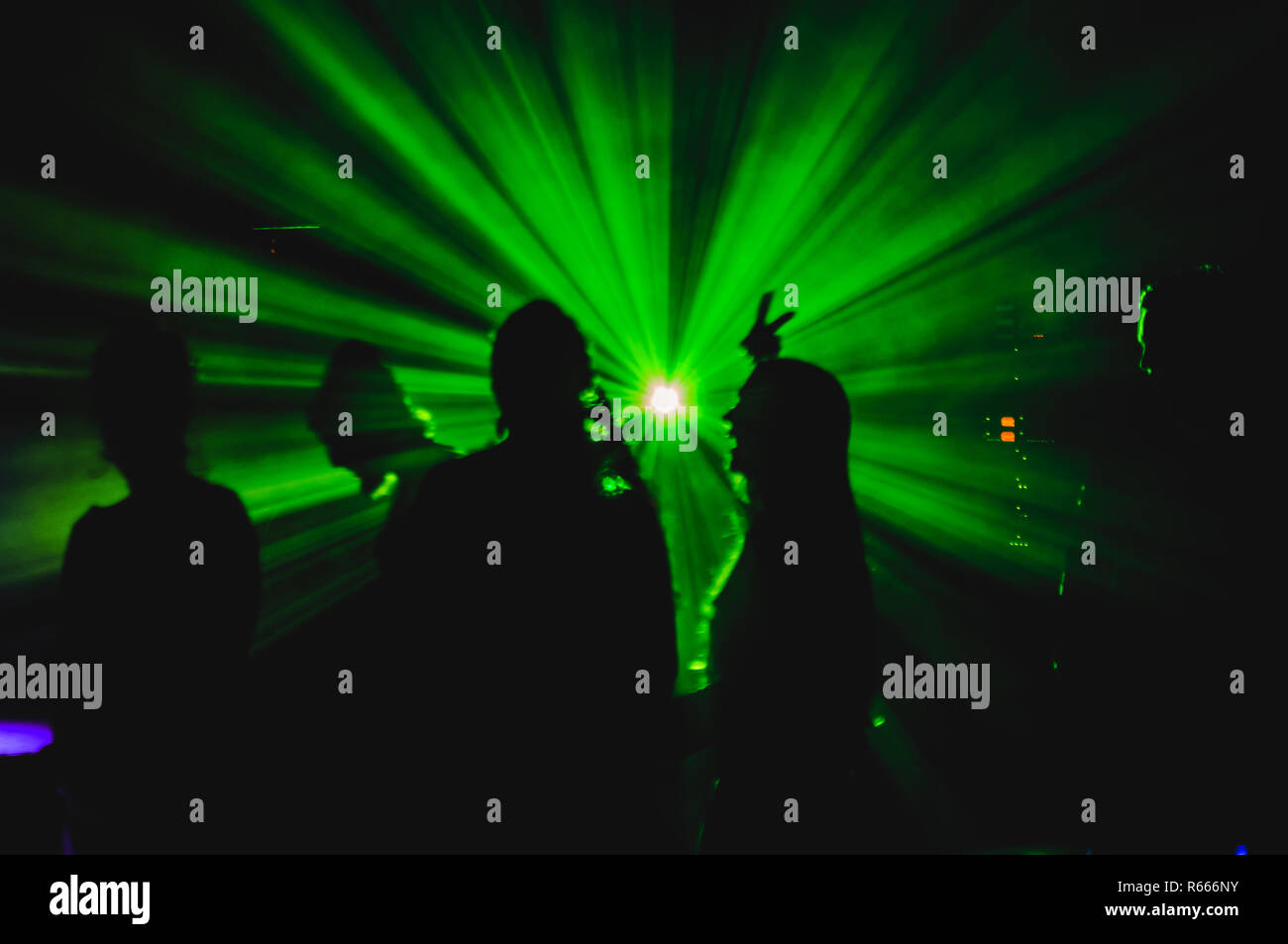 Male and Female dancers silhouetted by the lights in the night club. Stock Photo