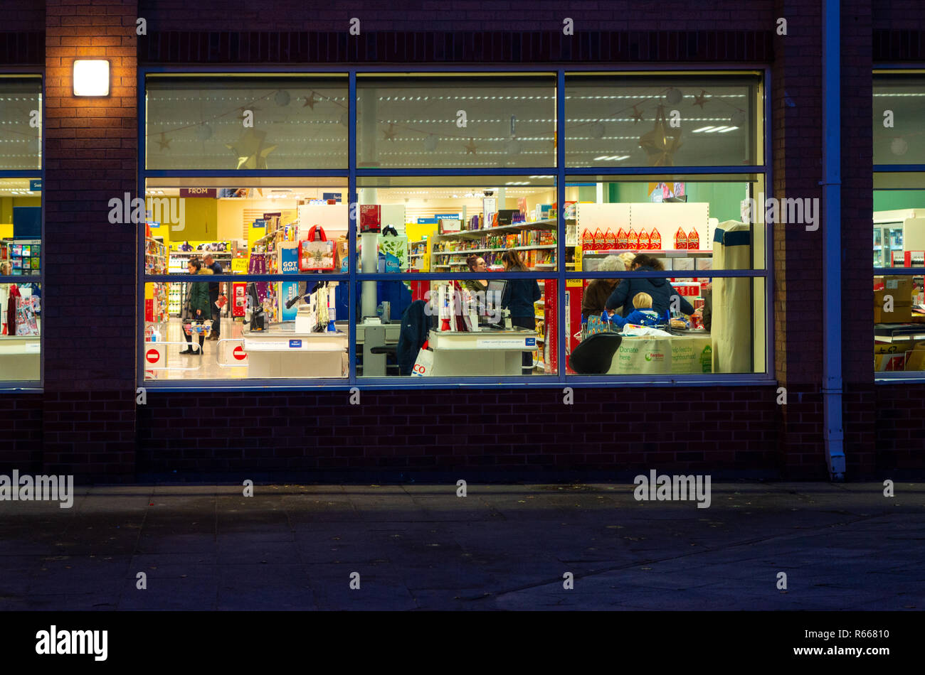 Dusk image of an illuminated shop front of Tesco Supermarket at