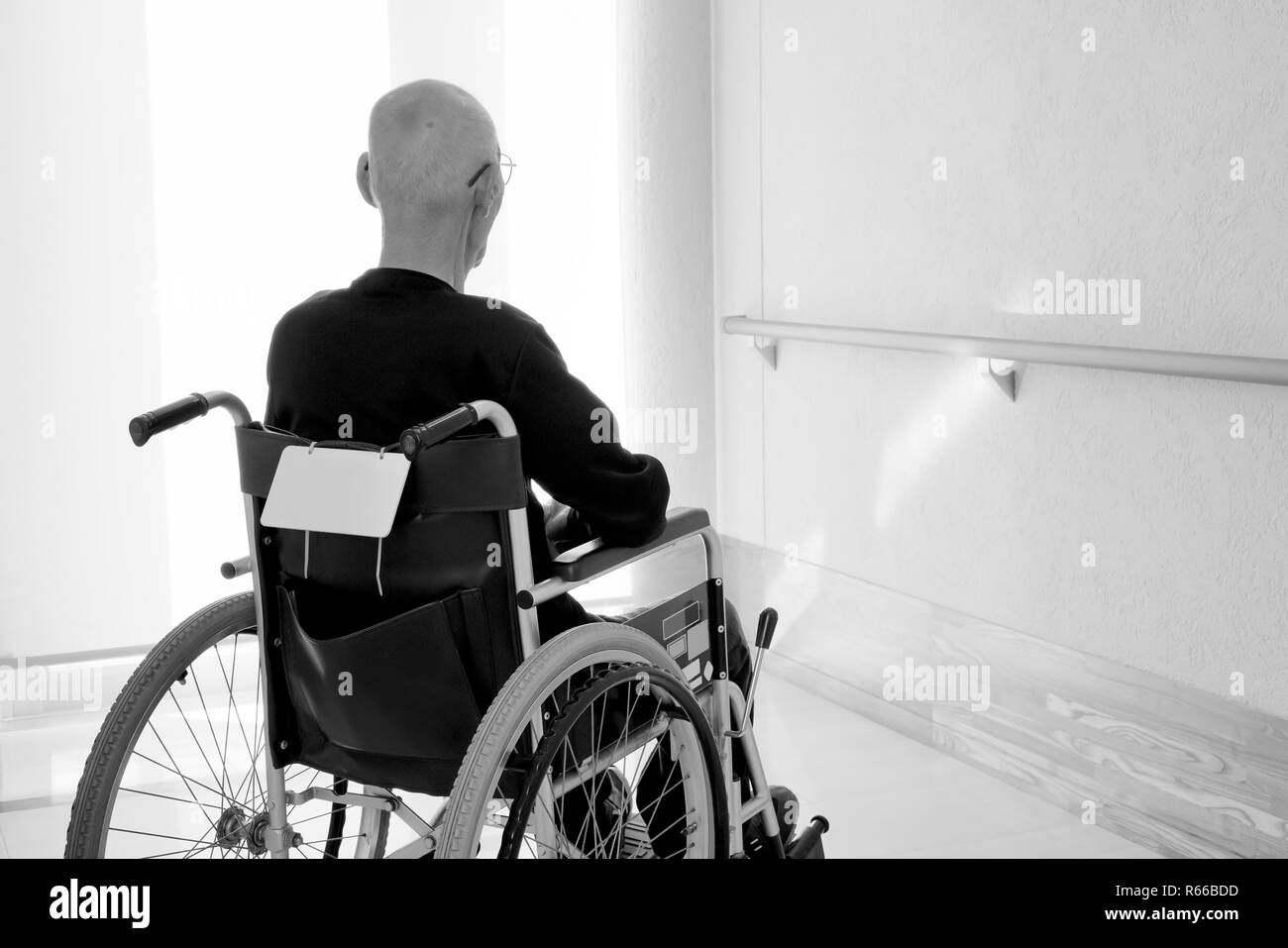 Back view of senior or elderly man on wheelchair at hospital hallway Stock Photo