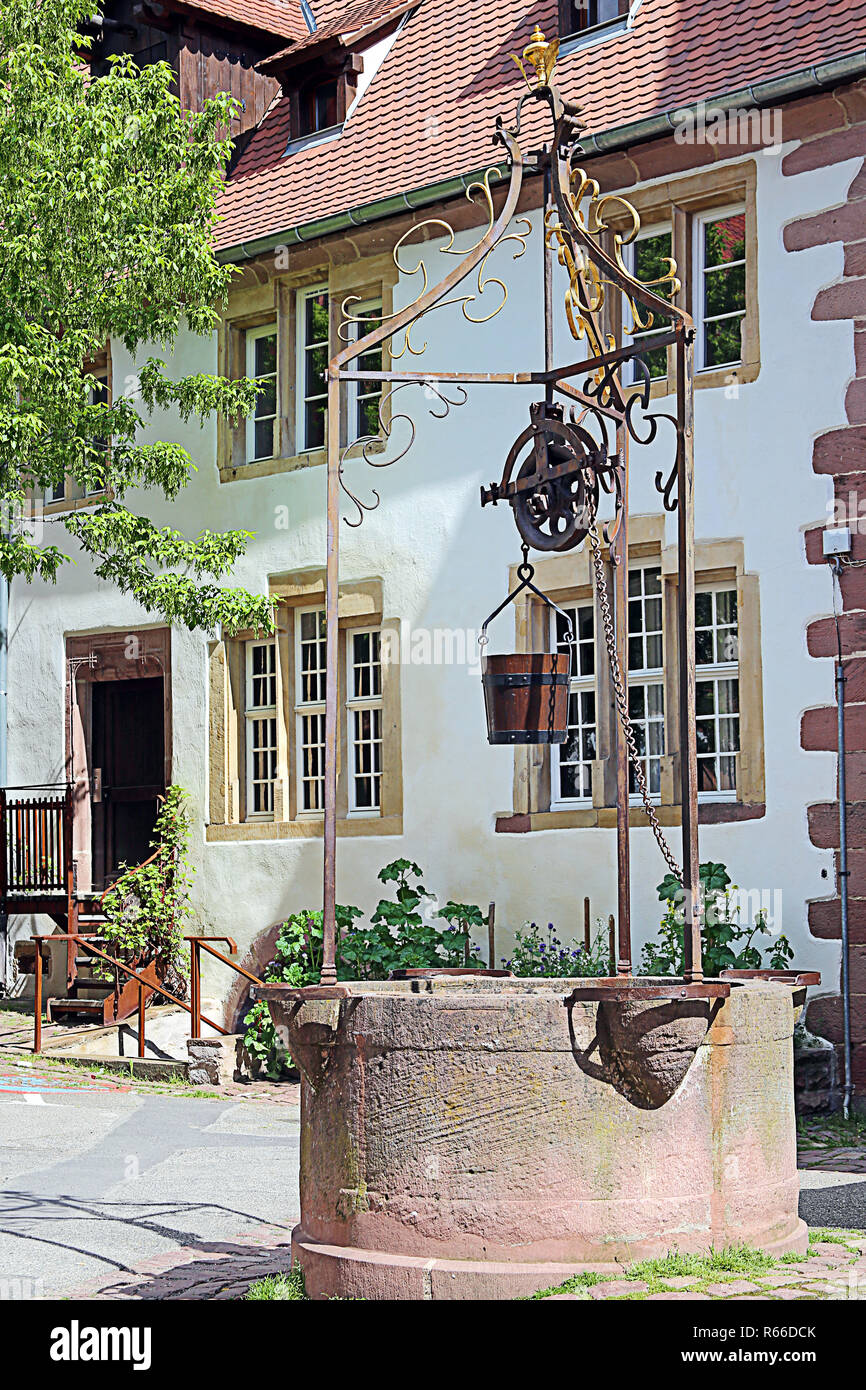 old fountain in front of saint erhard in riquewihr in alsace Stock Photo