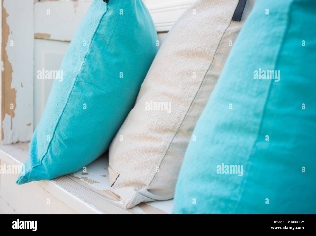 Colourful pillows on white wooden bench Stock Photo