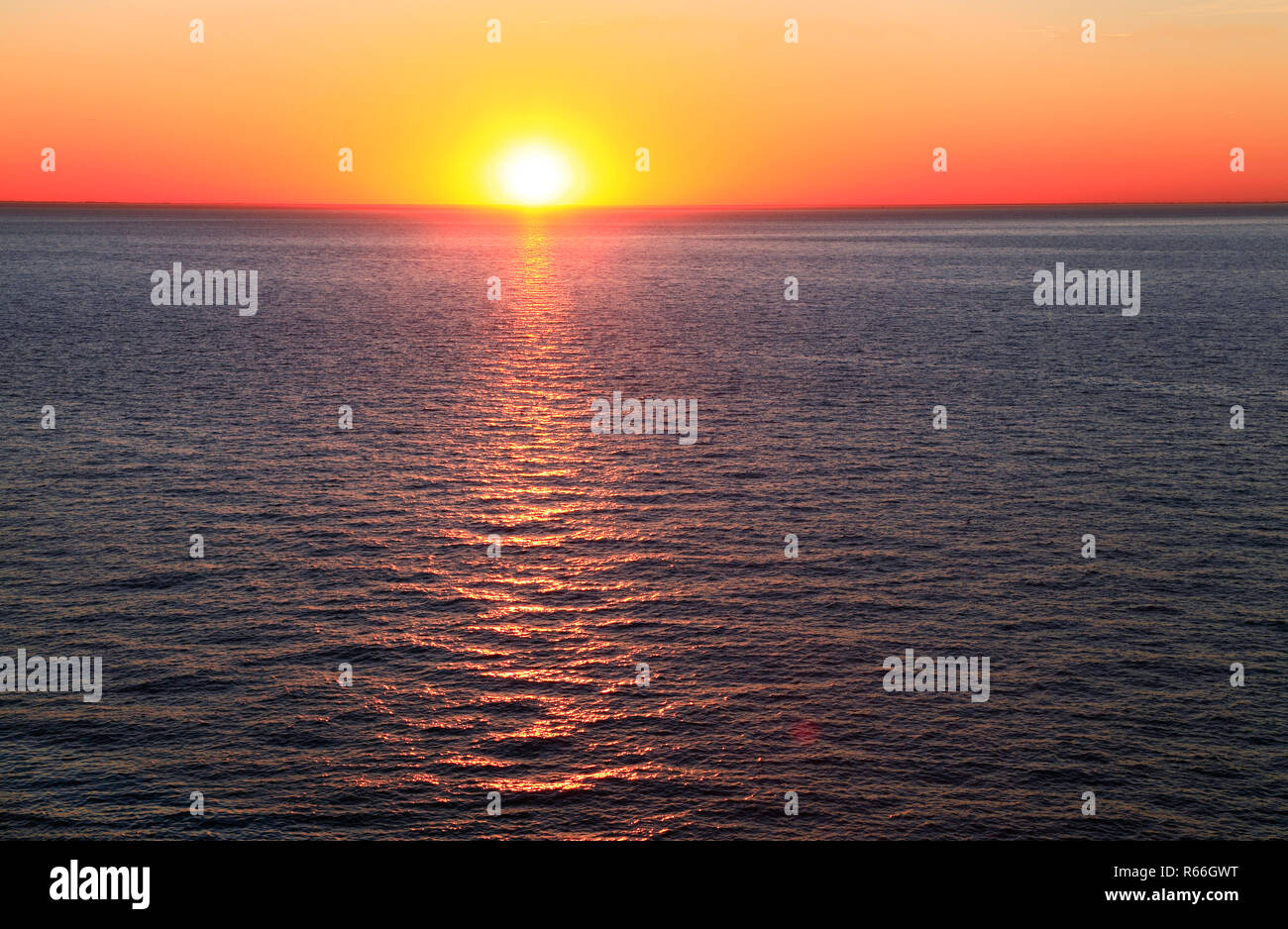 Sunset, Sea, red, orange, sky, The Wash, North Sea, sun ray, on water, west facing coast, Norfolk, UK Stock Photo