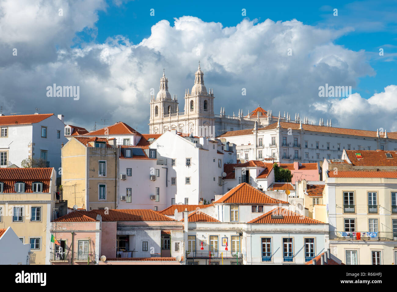 Mosteiro de Sao Vicente de Fora church and monastery above the red tile roofs and colorful buildings of the Alfama district in Lisbon, Portugal Stock Photo