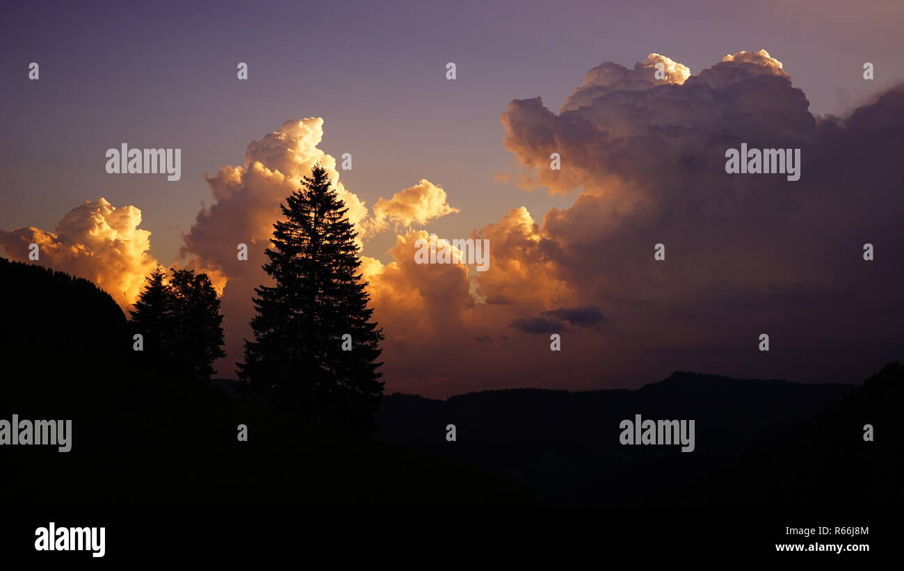 thunderclouds pile up behind a weathercane Stock Photo