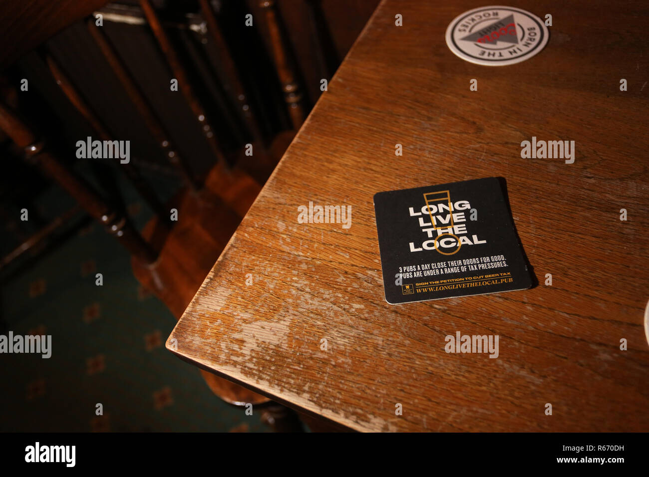 Beermat in a small local pub promoting the local pub reading 'Long Live the Local'. Pictured in Bognor Regis, West Sussex, UK. Stock Photo