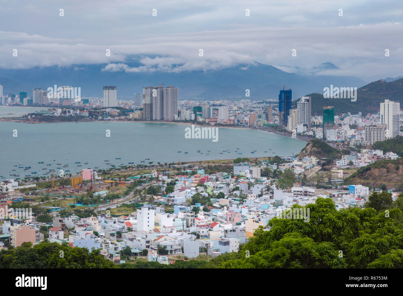 Holiday resort Nha Trang Vietnam on a cloudy day from a view point north of the city. With the mountains in the background and the turquoise south china sea to the left. Stock Photo