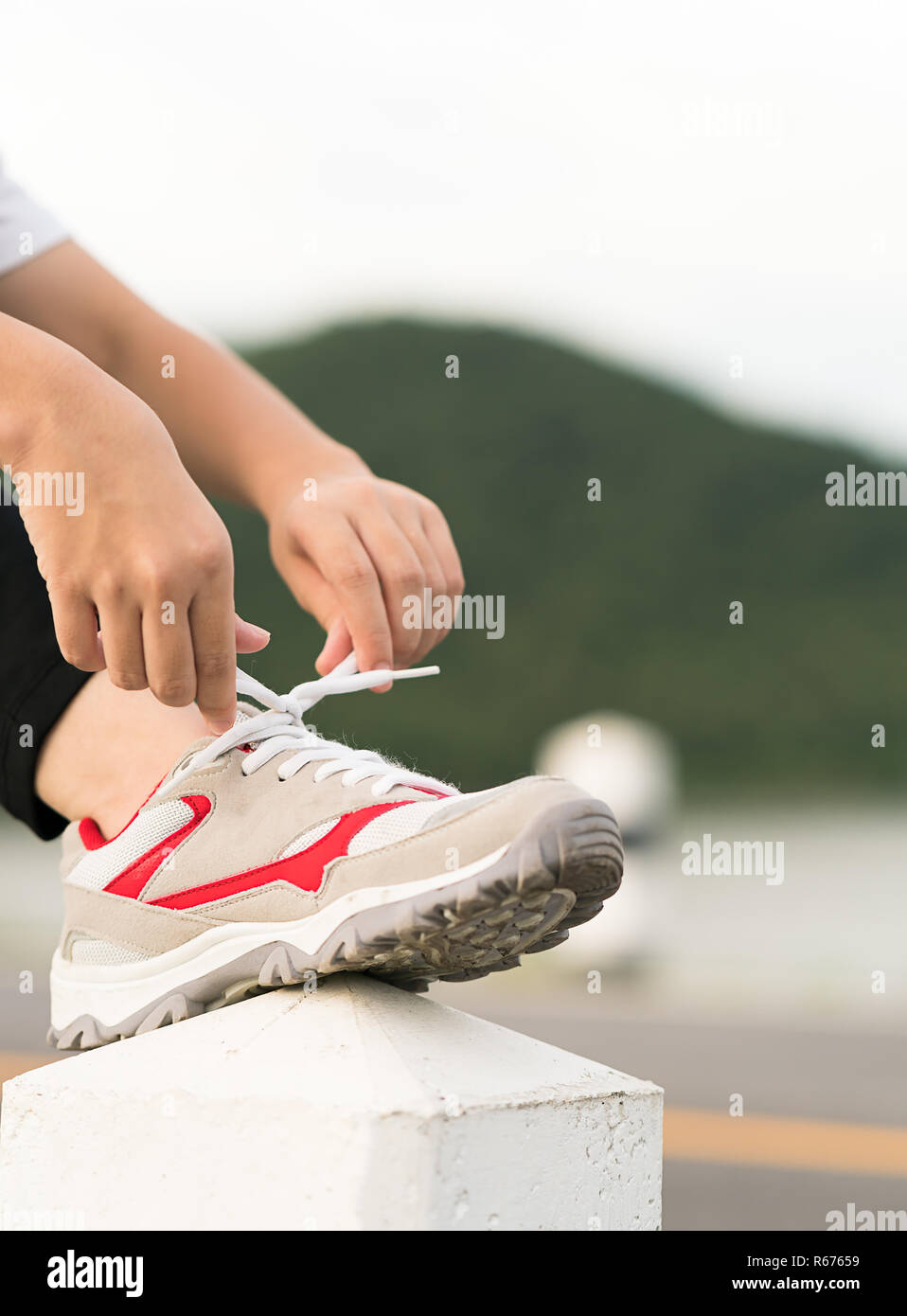 Woman tying shoelace his before starting running Stock Photo - Alamy
