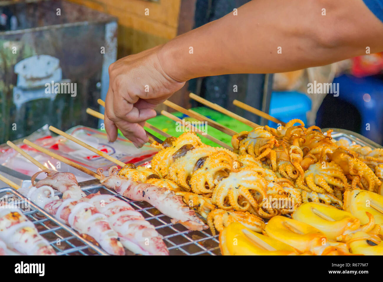 Use a hand of grilled squid on wire mesh. Stock Photo