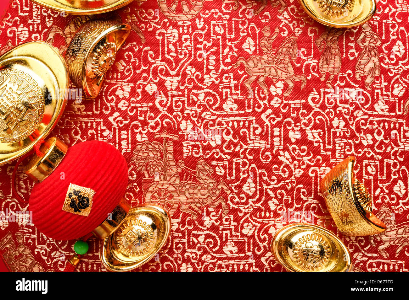 Chinese new year decoration,close up golden ingots ( ang pow )and lamp on red oriental pattern fabric hexagon box with chinese style pattern on red,Ch Stock Photo