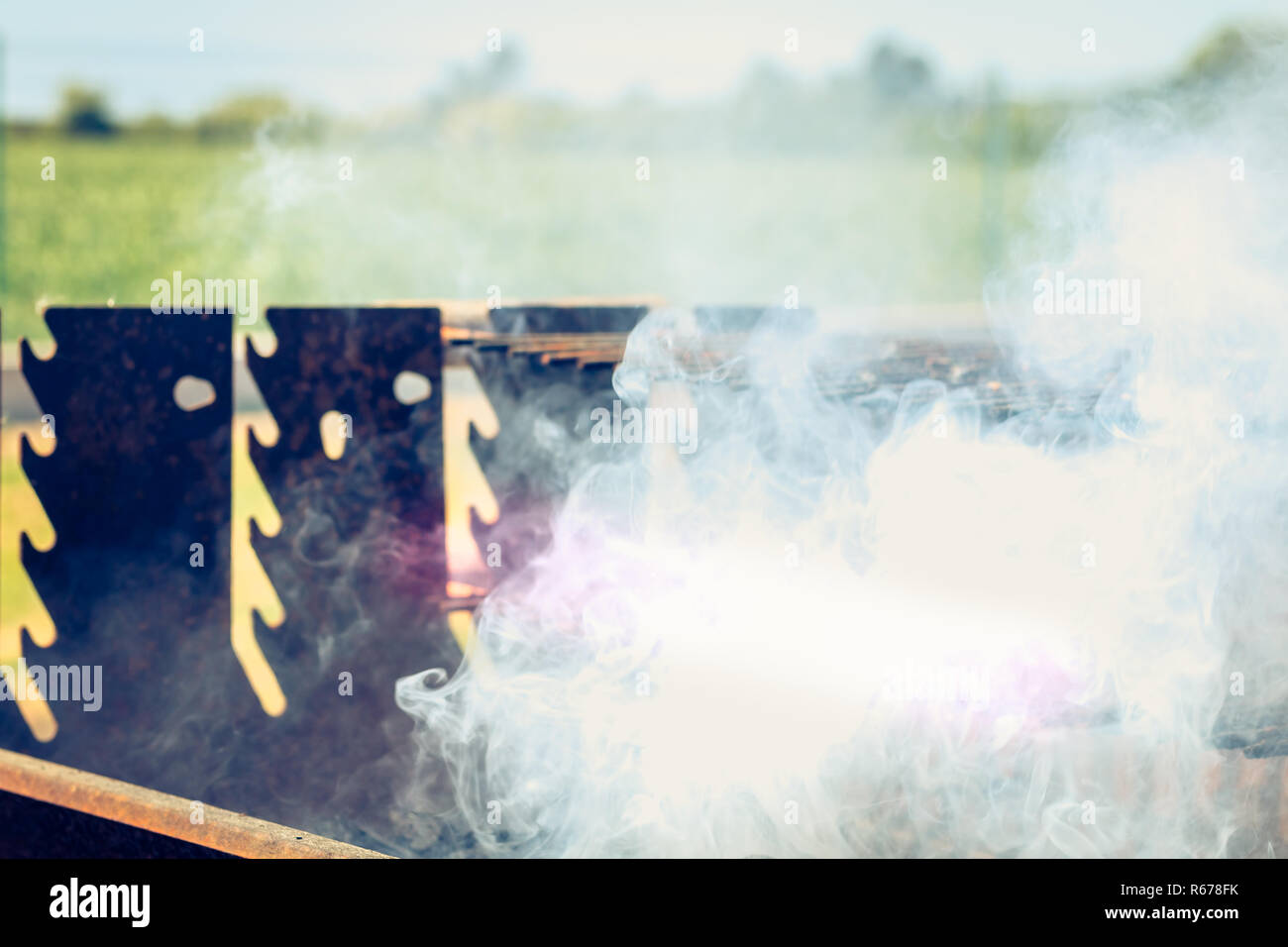 an old rusty steaming barbecue when lighting in garden Stock Photo