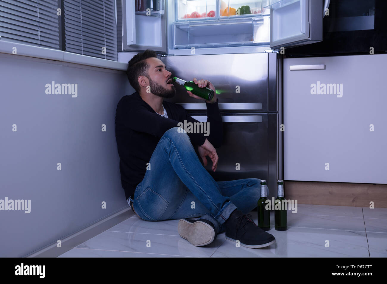 Man Sitting On Floor Drinking Beer Stock Photo - Alamy