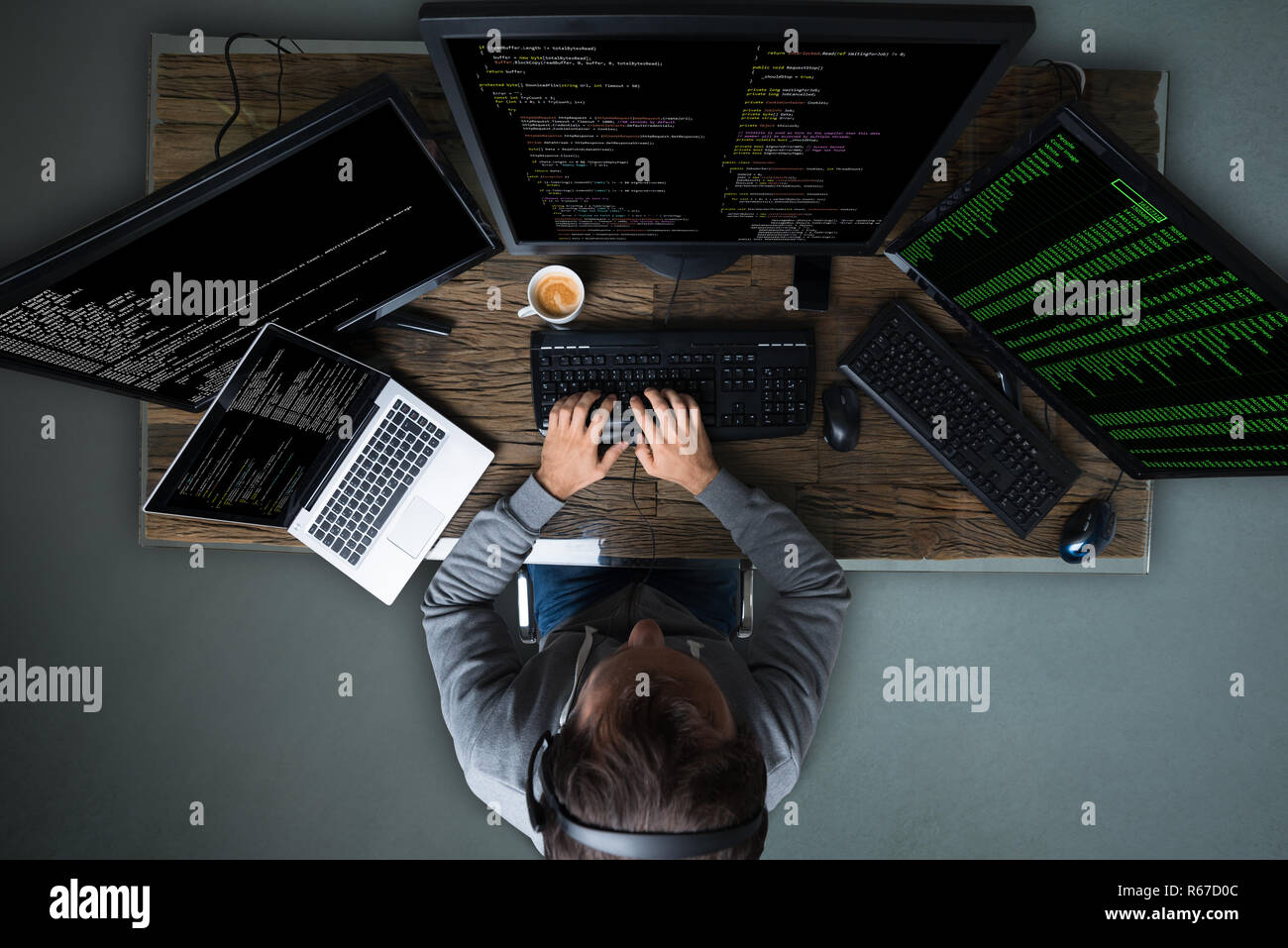 Hacker Hacking Multiple Computers On Desk Stock Photo
