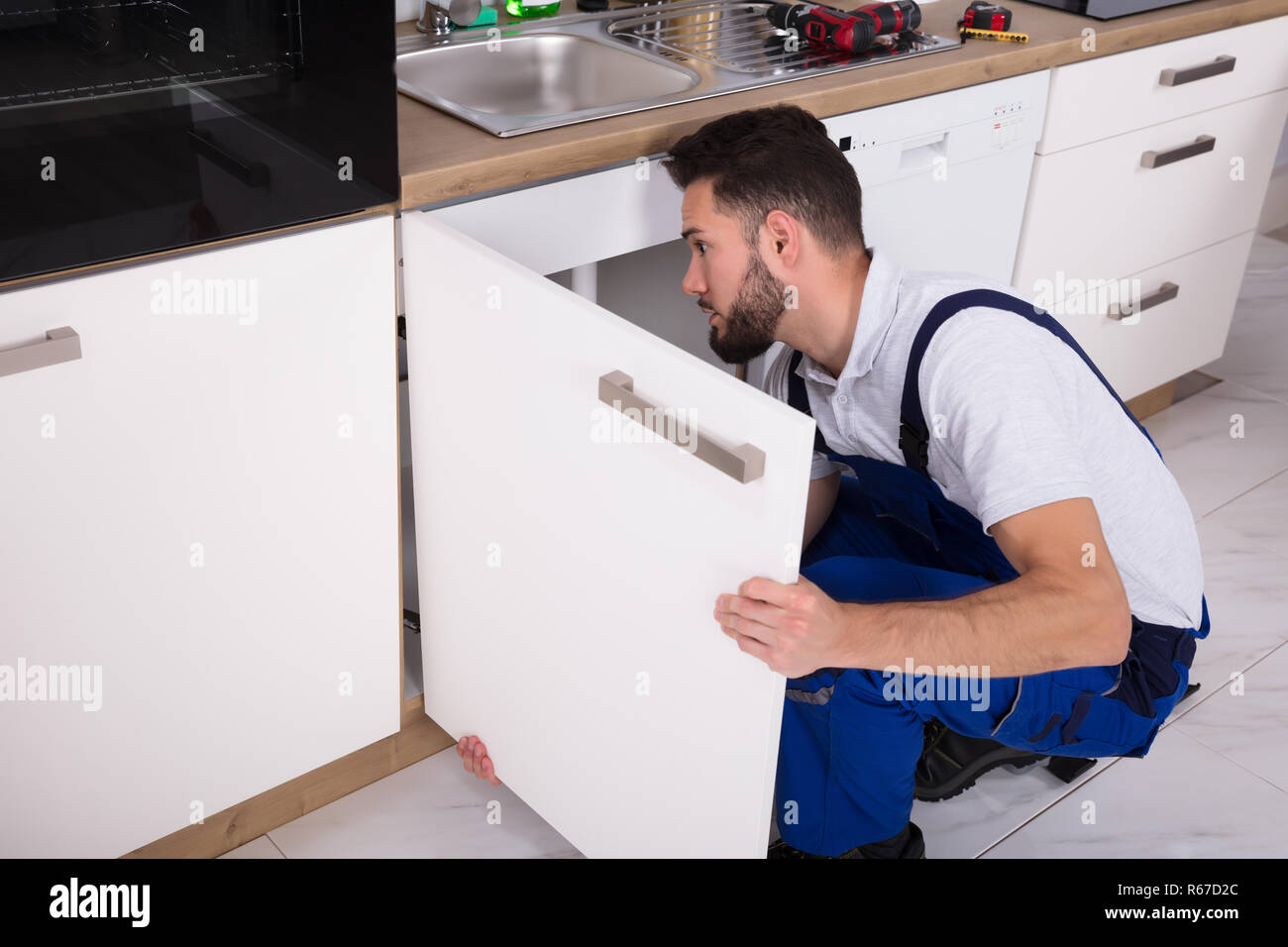 Handyman Fixing Sink Door Stock Photo - Alamy