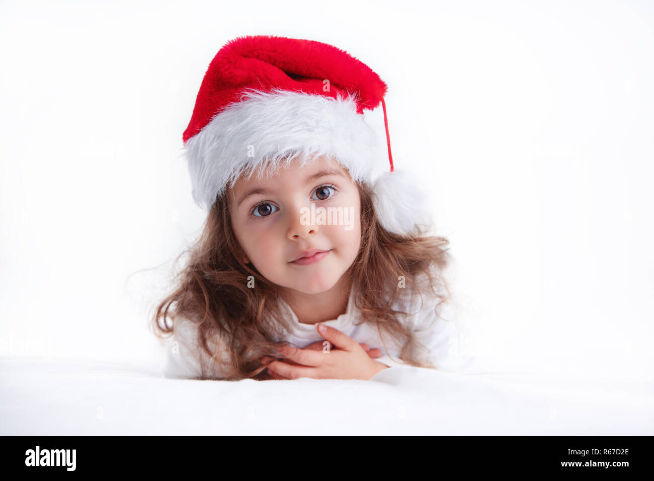 Christmas time, little girl in Santa Claus hat smilling. Stock Photo