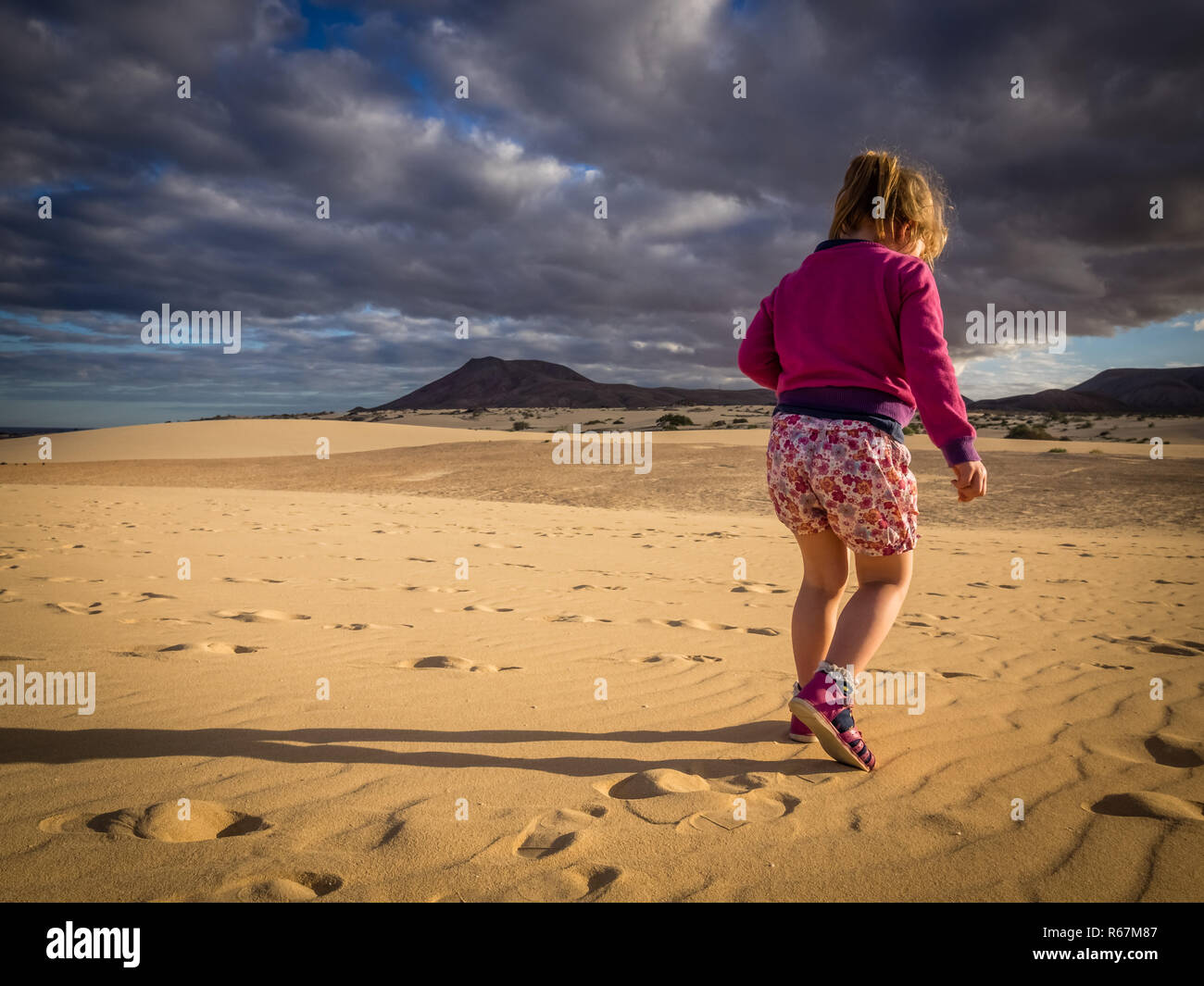 Little girl walking on the sand dunes Stock Photo Alamy
