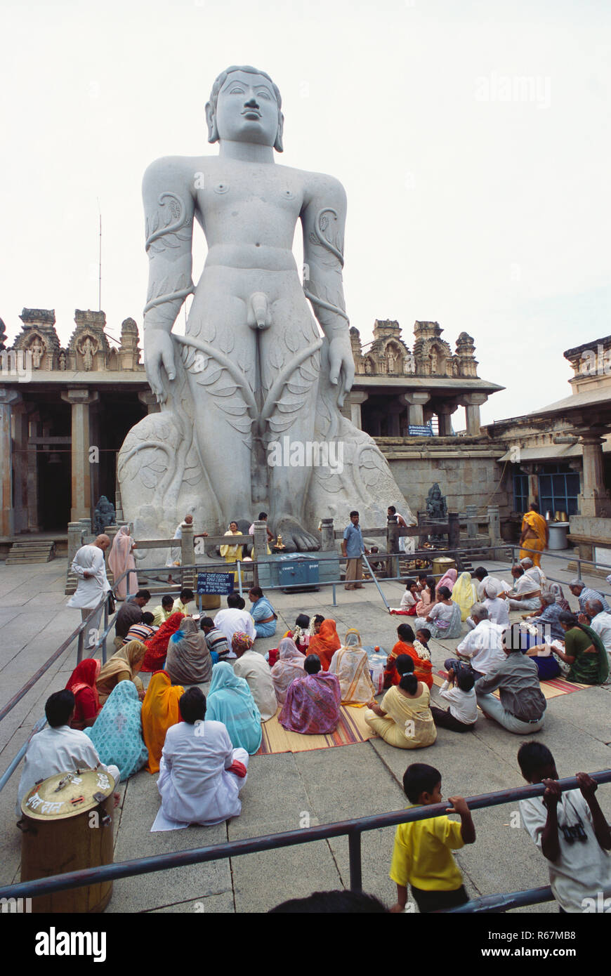 Jain Devotees praying to 58.8 feet Statue of saint Gomateshwara Lord Bahubali in Mahamastakabhisheka on Vindhyagiri, Shravanbelagola, Karnataka, India Stock Photo